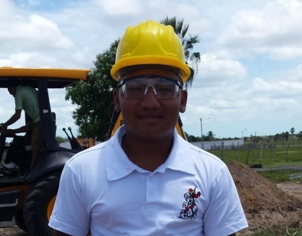 Anderson usando capacete de trabalho em uma fotografia da sua trajetória
